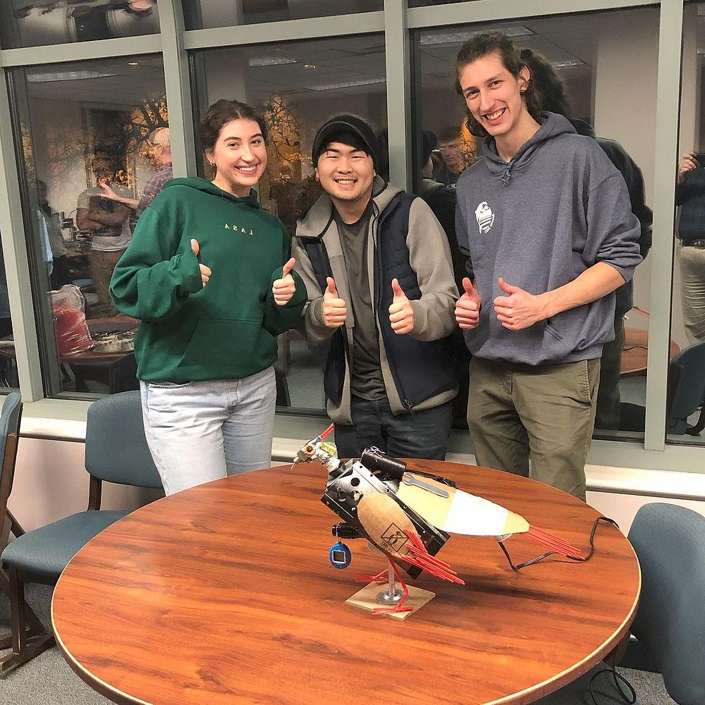 获胜队的三名学生展示他们的鸟雕塑.